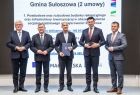Marszałek Witold Kozłowski i wicemarszałkowie Łukasz Smółka i Józef Gawron stoją na scenie z przedstawicielem Gminy Sułoszowa.