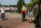 Iwona Gibas z zarządu województwa składa wieniec przed tablicą.