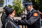 Wicemarszałek Łukasz Smółka przypina odznaczenie kobiecie strażakowi.