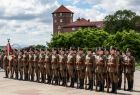 Kompania reprezentacyjna straży granicznej stoi na dziedzińcu wawelskim. W tle widoczna zabytkowa wieża zamkowa.