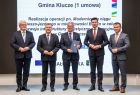 Marszałek Witold Kozłowski i wicemarszałkowie Łukasz Smółka i Józef Gawron stoją na scenie z przedstawicielem Gminy Klucze.