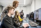 Marta Malec-Lech z zarządu województwa razem z uczniami patrzy w monitor.