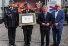 Marszałek Witold Kozłowski i wicemarszałkowie Łukasz Smółka i Józef Gawron stoją ze strażakiem trzymającym medal Polonia Minor.