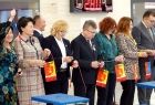 Marszałek Witold Kozłowski, poseł Anna Paluch, radna Marta Mordarska, wojewoda Łukasz Kmita, samorządowcy stoją obok siebie, w rękach trzymają proporce w kolorach czerwieni i złota. Za nimi widać ścianę w wyłożoną kaflami w kolorze brzoskwiniowym. 