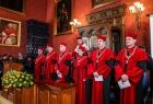 Władze Uniwersytetu Jagiellońskiego, w czerwonych szatach, stoją podczas uroczystości.