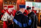 Rektor wręcza doktorat honoris causa Wiesławowi Myśliwskiemu.