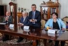 Marszałek Witold Kozłowski trzyma w rękach nagrodę. Po bokach siedzą członkowie komisji. W tle widoczne zabytkowe meble.