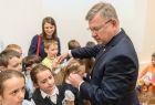 Marszałek Witold Kozłowski stoi w otoczeniu małych dzieci w pierwszym rzędzie widać trzy dziewczynki ubrane w granatowe sukienki i białe koszule. Marszałek Wita się z dziećmi. 