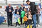 Marszałek Małopolski Witold Kozłowski unosi rękę jednego z udekorowanych dzieci pamiątkowymi medalami. Obok stoi Grzegorz Biedroń prezes MOT