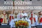 Widok na ołtarz polowy i kapłanów odprawiających Msze Św. ołtarz przyozdobiony jest bukietem ze słoneczników i zboża. nad głowami Kapłanów widać napis 24 Dożynki Województwa Małopolskiego.