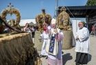 Metropolita Krakowski abp. Marek Jędraszewski ogląda ustawione na balach słomy wieńce dożynkowe.