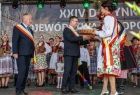 Scena dożynek Wojewódzkich. Marszałek Małopolski Witold Kozłowski odbiera symboliczne dary od pary ubranych w stroje regionalne