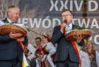 Marszałek Witold Kozłowski na scenie trzyma symboliczne dane i przemawia do publiczności. 