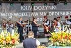 Marszałek Witold Kozłowski na scenie trzyma symboliczne dane i przemawia do publiczności.