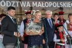 na scenie marszałek Łukasz Smółka, Iwona Gibas oraz Józef Gawron. Iwona Gibas trzyma kosz z darami po prawej ludzie w strojach regionalnych