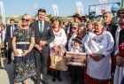 Marszałek Łukasz Smółka na dożynkach pozujący do zdjęcia z laureatami nagrody