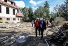 Marszałek Witold Kozłowski na placu budowy w tle za nim znajduję się remontowany Dom Podhalański w Ludźmierzu