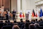 Widok na scenę filharmonii. Na której stoją Marszałek Witold Kozłowski i przedstawiciele władz samorządowych z Małopolski i Turyngii. Na scenie ustawiono flagę Polski, Małopolski, Niemczech i Unii Europejskiej. 