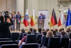 Widok na scenę filharmonii. Na której stoją Marszałek Witold Kozłowski i przedstawiciele władz samorządowych z Małopolski i Turyngii. Na scenie ustawiono flagę Polski, Małopolski, Niemczech i Unii Europejskiej.