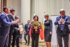 Marszałek Witold Kozłowski i przedstawiciele władz samorządowych z Małopolski i Turyngii. Kobieta stojąca na scenie trzyma kwiaty. 
