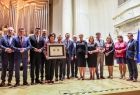 Widok na scenę w filharmonii, Marszałek Witold Kozłowski i przedstawiciele władz samorządowych z Małopolski i Turyngii. Wszyscy pozują do zdjęcia. Marszałek trzyma Medal Polania Minor.