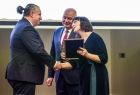 Dwie osoby wręczają statuetkę laureatowi