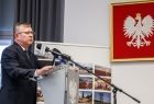 Marszałek Witold Kozłowski przemawia ze sceny. Na ścianie widoczne godło Polski.
