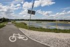 Droga rowerowa na bulwarze nad rzeką, w tle stoją ludzie.