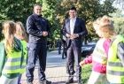 Wicemarszałek Łukasz Smółka stoi z komendantem policji, na pierwszym planie dzieci.