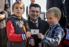 Wicemarszałek Łukasz Smółka z dziećmi trzymającymi kartę z napisem Małopolska.