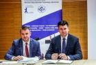 Wicemarszałek Łukasz Smółka siedzi przy stole z dyrektorem Wcisło.