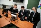 Wicemarszałek Łukasz Smółka siedzi za kierownicą symulatora w towarzystwie ucznia i nauczyciela.