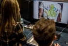 Uczniowie patrzą w monitor.
