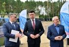 Wicemarszałek stoi z radnym. Za nimi flagi z napisem Fundusze Europejskie.