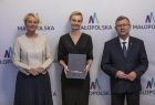 marszałek Witold Kozłowski i Iwona Gibas z zarządu z przedstawicielem Małopolskiej Rady Pożytku Publicznego, w tle ścianka z logo Małopolski