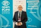 Wicemarszałek Józef Gawron na tle bannerów z napisem "Open Eyes Economy Summit"