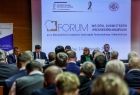 Uczestnicy wydarzenia siedzą na sali. Przed nimi napis jest wyświetlony napis Forum wójtów, burmistrzów i prezydentów Małopolski.