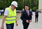Wicemarszałek rozmawia z robotnikiem w kasku i żółtej kamizelce.