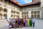 Nauczyciele stoją w rzędzie na dziedzińcu arkadowym Zamku na Wawelu