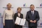 marszałek Witold Kozłowski i Iwona Gibas z zarządu z przedstawicielem Małopolskiej Rady Pożytku Publicznego, w tle ścianka z logo Małopolski