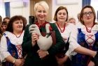Iwona Gibas z Zarządu Województwa Małopolskiego, trzymająca szmacianą figurkę koguta, wraz z paniami w strojach ludowych