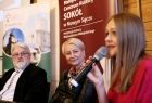 Iwona Gibas z zarządu województwa małopolskiego oraz dyrektorzy małopolskich instytucji kultury słuchają wypowiedzi kobiety mówiącej do mikrofonu