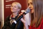 Iwona Gibas z zarządu województwa małopolskiego przysłuchuje się wypowiedzi kobiety mówiącej do mikrofonu