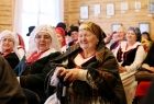 Starsze panie w strojach ludowych siedzące w sali dworu na terenie skansenu w Wygiełzowie