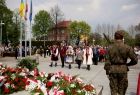 Kwiaty składa delegacja zespołu śpiewaczego w strojach ludowych