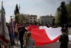 Poczty sztandarowe i dzieci niosące wielką biało-czerwoną flagę na placu Tadeusza Kościuszki w Oświęcimiu