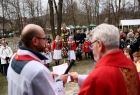 Kapłani i wierni z palmami wielkanocnymi przed kościołem w skansenie w Wygiełzowie