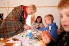 Iwona Gibas z zarządu województwa pomagająca chłopcu podczas warsztatów plastycznych o wielkanocnej tematyce