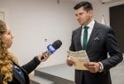 Wicemarszałek Łukasz Smółka udziela wywiadu telewizji.
