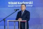 Marszałek Witold Kozłowski stoi przed mikrofonem. 